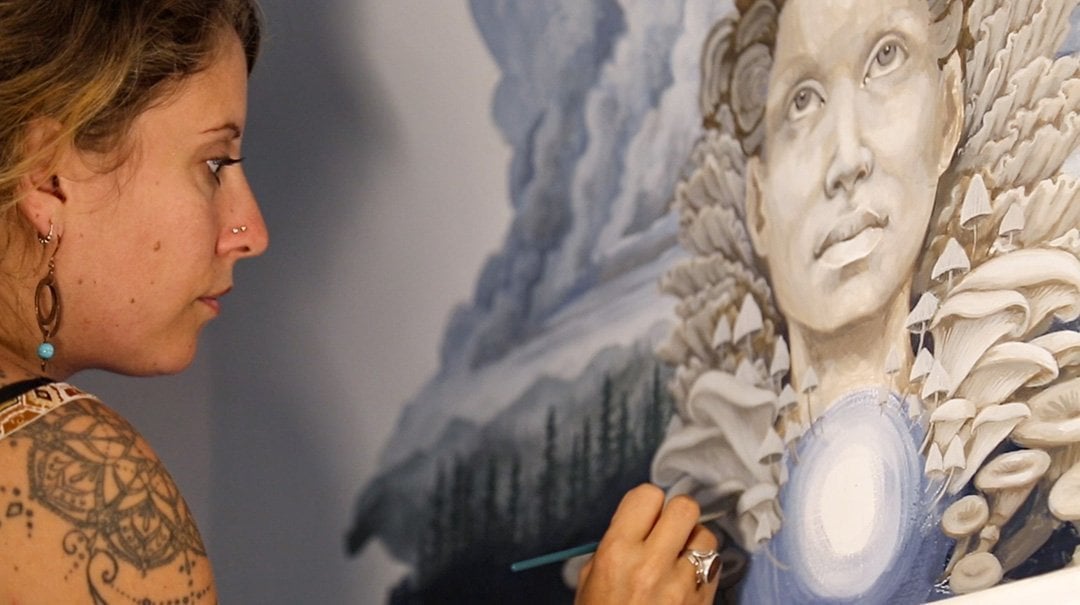 Autumn Skye painting the Mushroom Cafe mural.